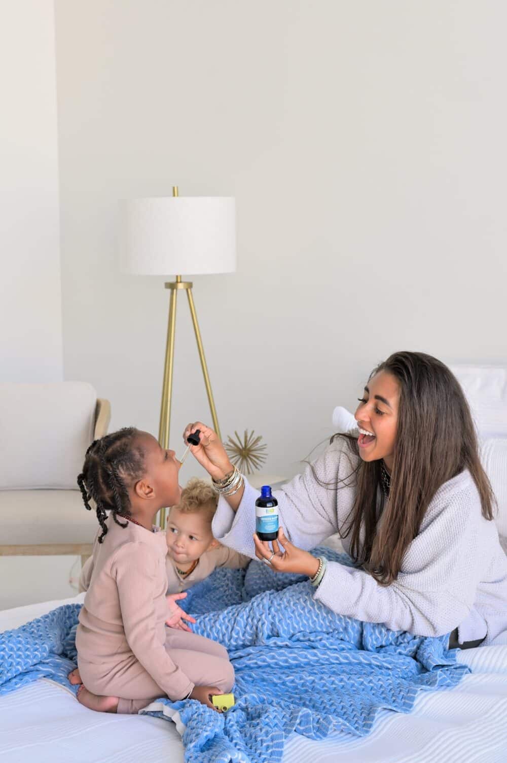 Image of Britney Ross administering a dose of Genesis Blend Extra Strength hemp CBD oil to her daughters.