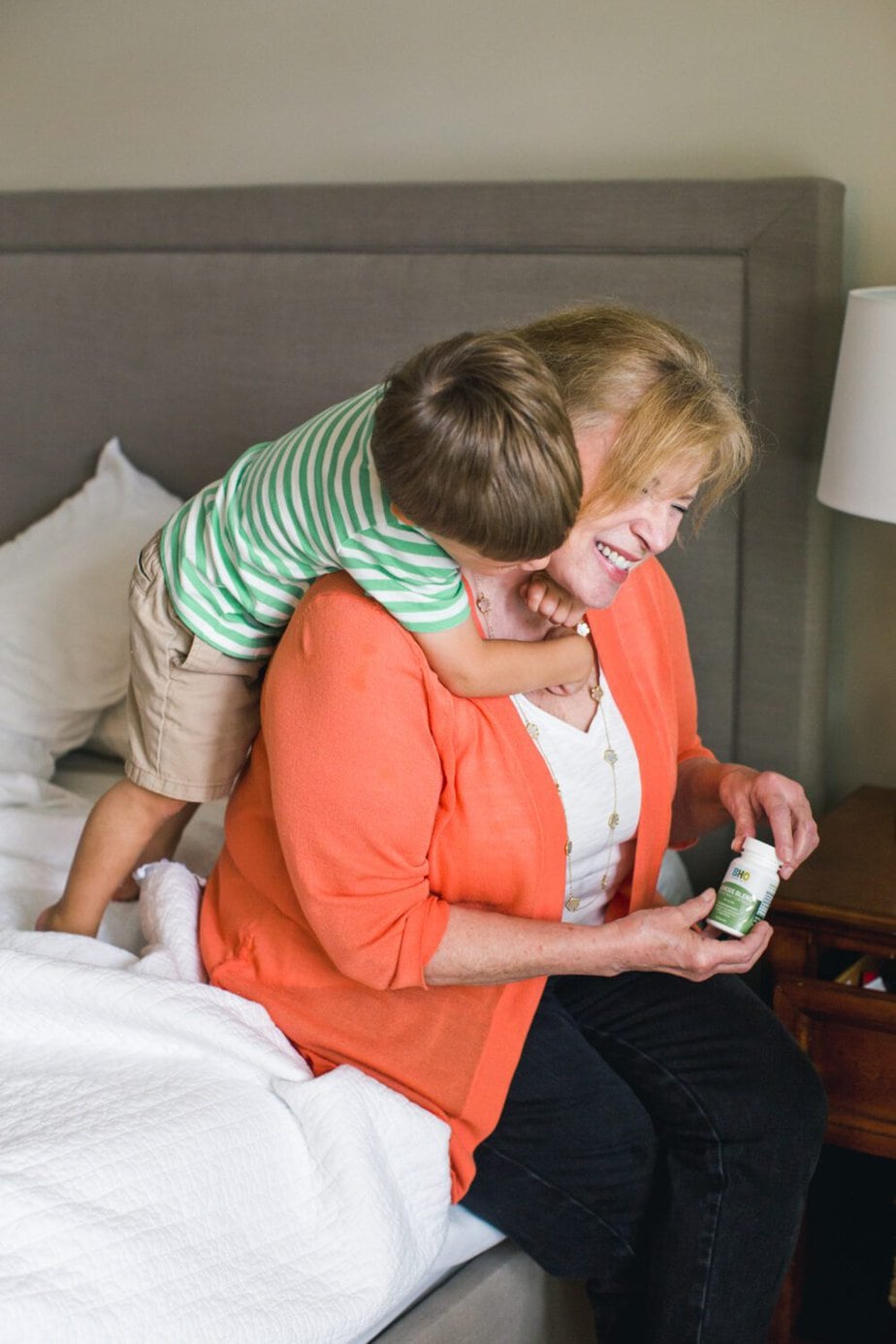 Grandson squeeze hugging Grandma. Grandma opened a bottle of Genesis Blend CBD Capsules.