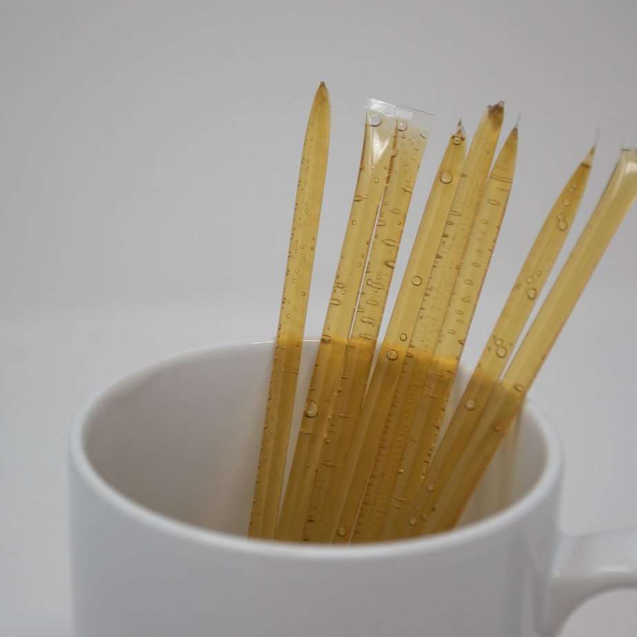 A white cup filled with multiple 10mg CBD Honey sticks.
