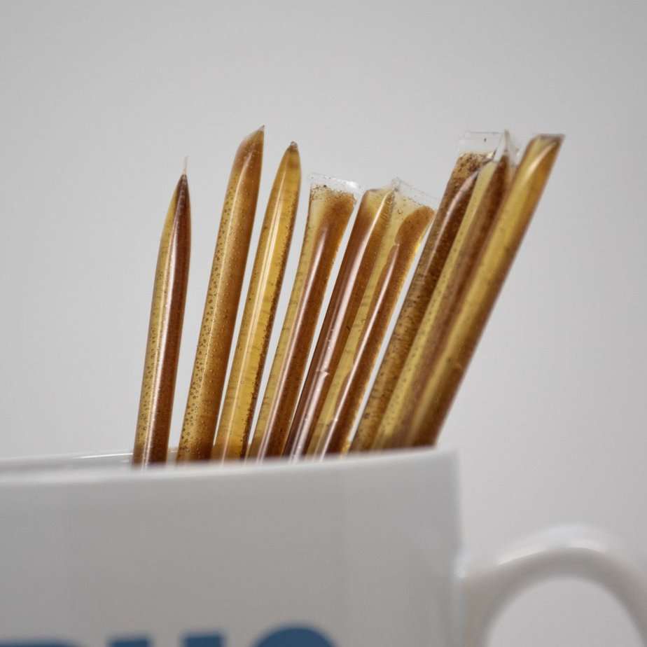 A white cup filled with 10mg cinnamon CBD honey sticks.