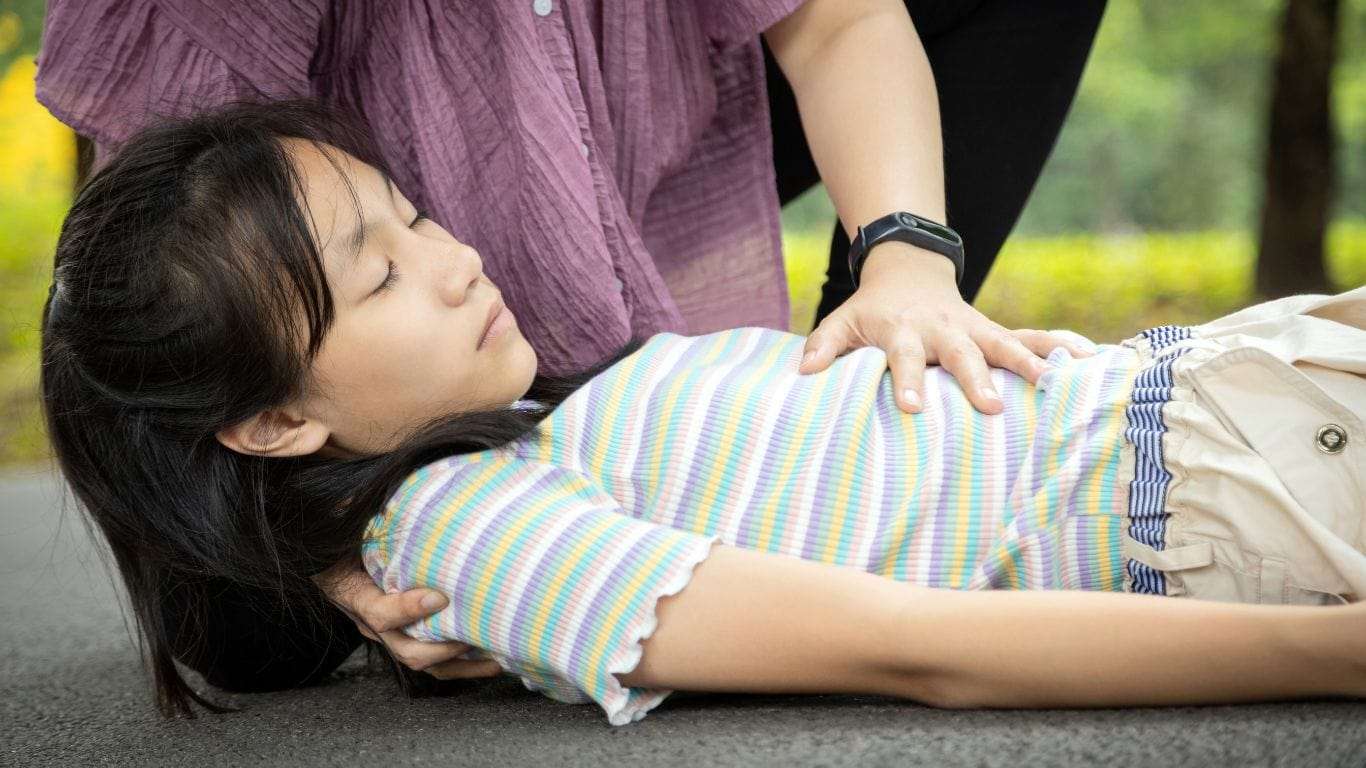 A young girl experiencing a drop attack, lying on the ground