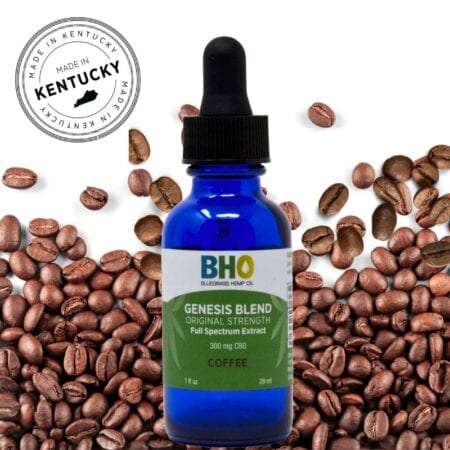 A one-ounce bottle of Genesis Blend Full Spectrum CBD Oil Coffee Flavor sits on a white background, surrounded by roasted coffee beans and a round logo with bold text that says "Made in Kentucky."