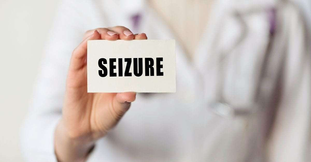 Doctor holding a card labeled 'Seizure' for Simple Partial Seizures