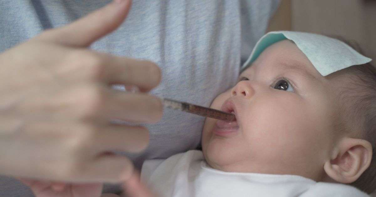 Mother administering full spectrum CBD oil to her infant as a treatment for infantile spasms.