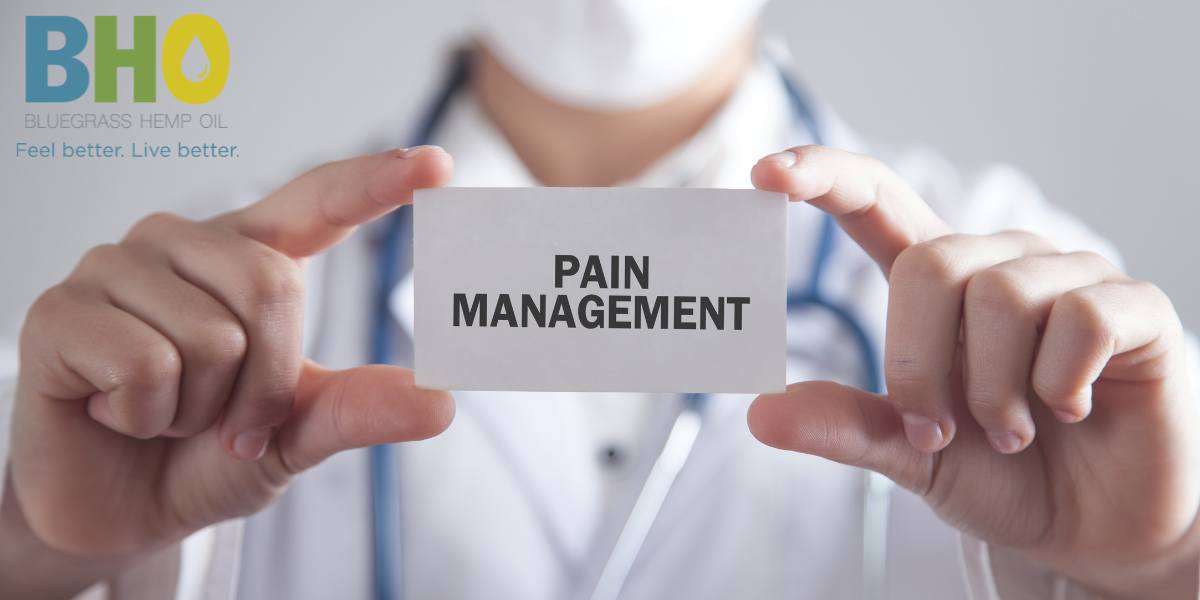 Doctor in white coat holding a card with 'Pain Management' text, symbolizing medical expertise in pain relief.