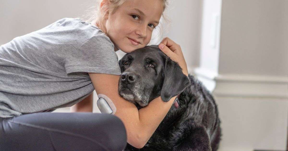 Girl and her dog, both with diabetes, sitting together using full spectrum CBD oil for health management.